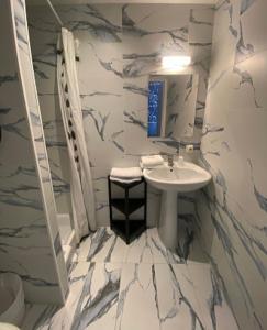 a bathroom with a sink and a marble wall at Interlaken in Nice