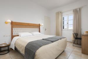 a bedroom with a large bed and a window at Astir Of Naxos in Naxos Chora