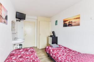 a small bedroom with a bed and a sink at Zee en Duin in Zandvoort