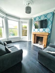 a living room with a couch and a fireplace at Gorgeous 3 Bedroom Victorian Townhouse in Lisburn