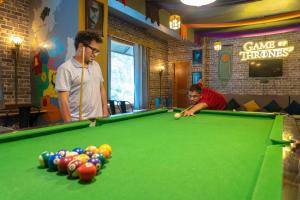two men playing a game of pool in a bar at Whoopers Hostel Kasol in Kasol