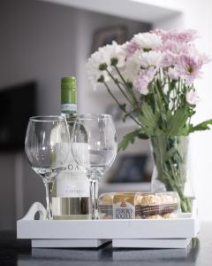 a table with two wine glasses and a vase of flowers at Gorgeous 3 Bedroom Victorian Townhouse in Lisburn