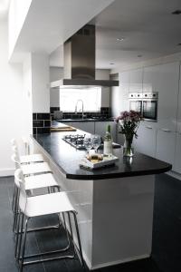 a kitchen with a black counter and white cabinets at Gorgeous 3 Bedroom Victorian Townhouse in Lisburn