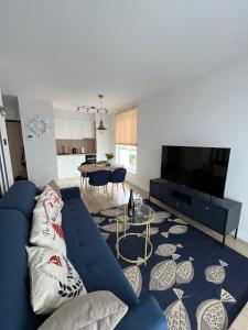 salon z niebieską kanapą i stołem w obiekcie Villa Neptun - apartament przyjazny zwierzętom w Gdańsku