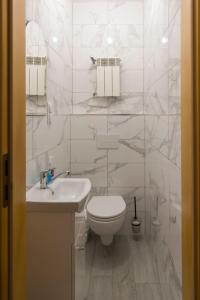 a white bathroom with a toilet and a sink at Willa Basinek in Muszyna