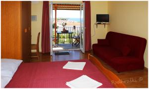 een woonkamer met een rode bank en een rode deken bij Primosten Apartments in Primošten