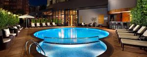 a swimming pool in a building with chairs and tables at Surmeli Istanbul Hotel in Istanbul