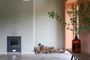 a room with a pile of fire wood and a vase at Pinewood Guesthouse in Mäntsälä