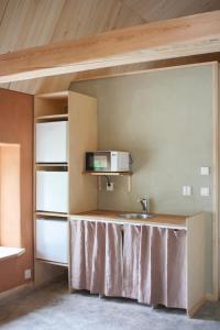 a kitchen with a table and a sink in a room at Pinewood Guesthouse in Mäntsälä