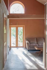uma sala de estar com um sofá e uma janela em Pinewood Guesthouse em Mäntsälä