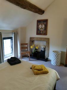 a bedroom with a large bed and a fireplace at Clover Cottage in Winster