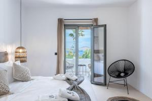 Schlafzimmer mit einem weißen Bett und einem Spiegel in der Unterkunft PAREA Paros - Adults Only in Kampos Paros