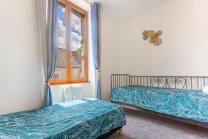 a bedroom with two beds and a window at Monesto Gite maison de ville cité médiévale in Mennetou-sur-Cher