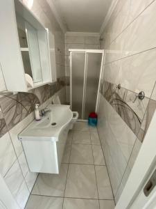 a white bathroom with a sink and a shower at GÖKTÜRK APART in Trabzon +53 photos