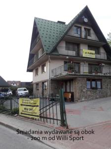 a large building with a sign in front of it at Willa Sport in Zakopane