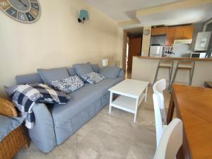 a living room with a blue couch and a table at Calafell Sant Antoni in Calafell