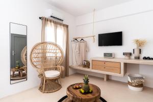 a living room with a tv and a chair and a table at PAREA Paros - Adults Only in Kampos Paros
