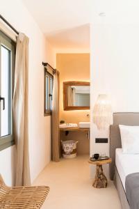 a bedroom with a bed and a sink and a mirror at PAREA Paros - Adults Only in Kampos Paros