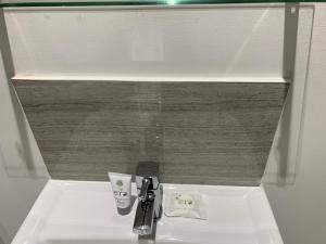 a bathroom sink with a faucet and a cup on it at Imperial Salford Hotel in Manchester