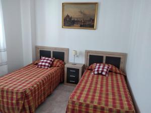 a room with two beds and a picture on the wall at Boutique Los Pinos in Denia