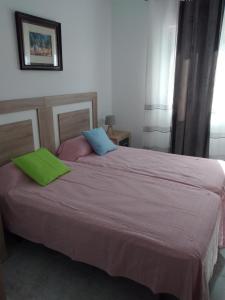 una camera da letto con un grande letto con cuscini verdi e blu di Boutique Los Pinos a Denia