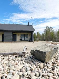 a large rock sitting on a pile of rocks in front of a building at Kelopyry in Syöte