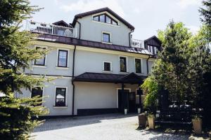 a white house with a balcony on top of it at Pensjonat Rozanna in Wąwolnica