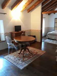 Habitación con mesa, sillas y cama en Locanda Orologio, en Cormòns
