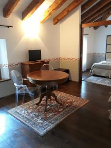 a room with a table and chairs and a bed at Locanda Orologio in Cormòns