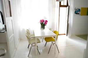una mesa de comedor con sillas amarillas y un jarrón de flores en Apartamenty Mrągowo Warszawska Cudo Studio, en Mrągowo
