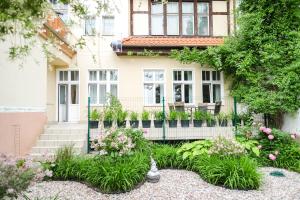 a garden in front of a house with flowers at Apartamenty Mrągowo Warszawska Cudo Studio in Mrągowo
