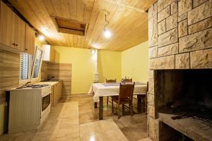 een keuken met een tafel en een keuken met een open haard bij Villa with a heated private pool, parking, BBQ in Petričevići