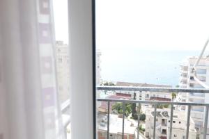 ein Fenster mit Blick auf das Meer und die Gebäude in der Unterkunft Albania Dream Holidays Accommodation in Sarandë