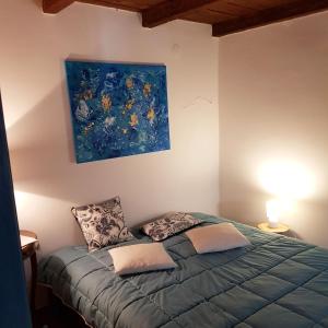 a bedroom with a bed with a painting on the wall at Ferienhaus Insel Murter Vivaldi/Stonehouse Betina in Betina