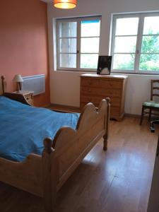 a bedroom with a bed and a dresser and windows at gite la cordée in Lavans-lès-Saint-Claude