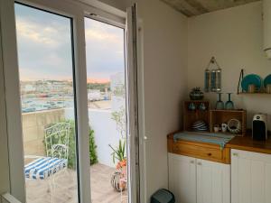 eine Küche mit einer Glasschiebetür, die auf einen Balkon führt in der Unterkunft Anthony's Sea Stay in Marsaxlokk