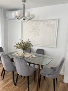 uma sala de jantar com uma mesa de vidro e cadeiras em Apartamento Dakota em Sant Carles de la Ràpita
