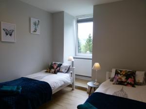 1 dormitorio con 2 camas y ventana en Apartament BB z widokiem na Krynicę, en Krynica-Zdrój