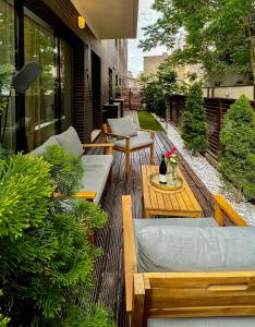 eine Terrasse mit Sofas, einem Tisch und Stühlen in der Unterkunft GREEN CORNER Apartment in Bukarest