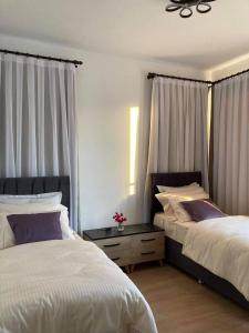 ein Schlafzimmer mit 2 Betten und einem Nachttisch dazwischen in der Unterkunft Luxury 2-bedroom condo with a private rooftop area in Boghaz