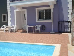 Casa con piscina, mesa y sillas en Mema's Apartment en Agia Efimia