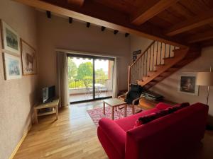 a living room with a red couch and a staircase at Ascona: Sabrina Apt.238 in Ascona