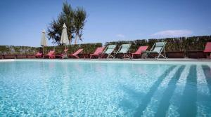 Un grupo de sillas junto a una piscina. en Valle Azzurra, en Galleno