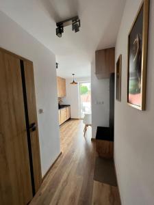 a hallway of an apartment with a door and a kitchen at Black Diamond 18 in Pasłęk