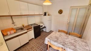 a small kitchen with a table and a counter top at Apartment Cuhas with Terrace in Baška