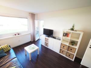 - un salon avec un canapé et une télévision dans l'établissement Appartement-173, à Westerland