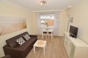 ein Wohnzimmer mit einem Sofa und einem Tisch in der Unterkunft Appartement 162 in Westerland