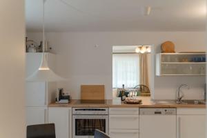 a kitchen with white cabinets and a stove top oven at Hideaway Sekirn in Maria Wörth