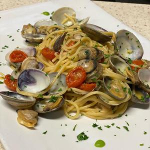 un plato de pasta con almejas y mejillones en AMBRA HOTEL - The only central lakeside hotel in Iseo en Iseo