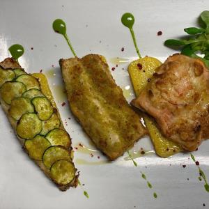 un plato de comida con pescado y verduras. en AMBRA HOTEL - The only central lakeside hotel in Iseo en Iseo